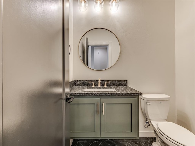 bathroom with toilet, baseboards, marble finish floor, and vanity