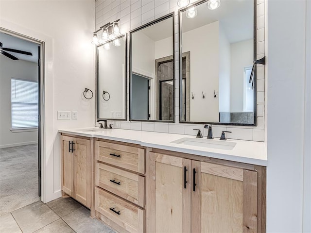 bathroom with double vanity, tile patterned floors, ceiling fan, and a sink