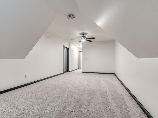 additional living space with ceiling fan, light carpet, baseboards, lofted ceiling, and visible vents