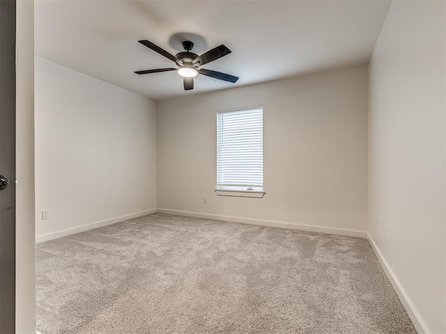 unfurnished room featuring baseboards, a ceiling fan, and carpet
