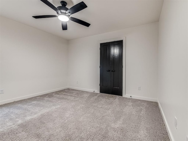 empty room featuring baseboards, ceiling fan, and carpet