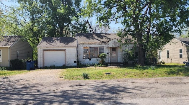ranch-style house with an attached garage, driveway, and a front lawn