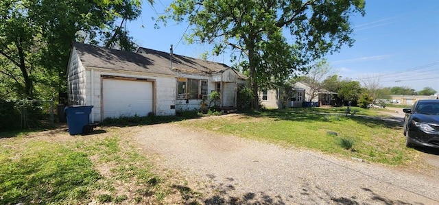 ranch-style house featuring a garage, dirt driveway, and a front yard