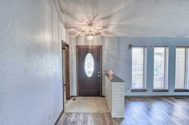 204 Sequoia Park Dr, Yukon, OK 73099 - entrance foyer featuring a textured ceiling, a textured wall, baseboards, and wood finished floors