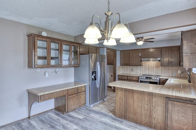 204 Sequoia Park Dr, Yukon, OK 73099 - kitchen with a sink, stainless steel appliances, ceiling fan with notable chandelier, under cabinet range hood, and backsplash