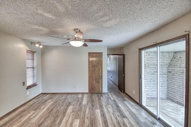 204 Sequoia Park Dr, Yukon, OK 73099 - empty room featuring a textured ceiling, a ceiling fan, plenty of natural light, and light wood-style floors