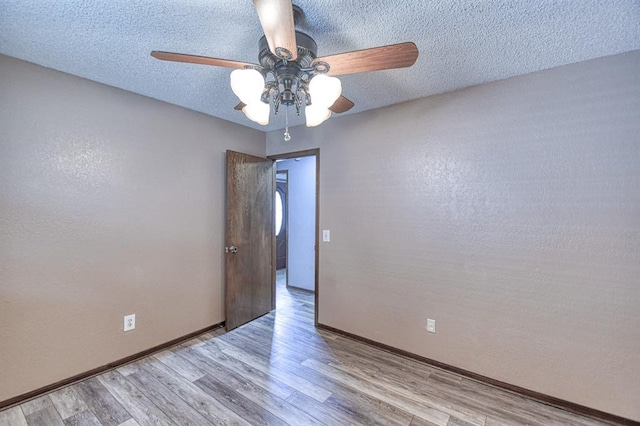 204 Sequoia Park Dr, Yukon, OK 73099 - spare room featuring a ceiling fan, baseboards, a textured ceiling, and wood finished floors