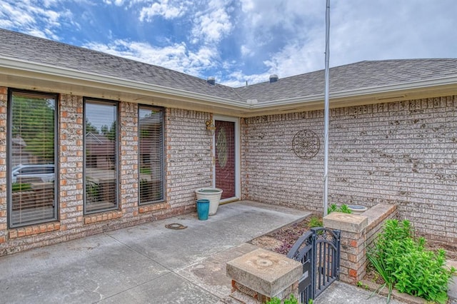204 Sequoia Park Dr, Yukon, OK 73099 - view of exterior entry featuring a patio area and roof with shingles
