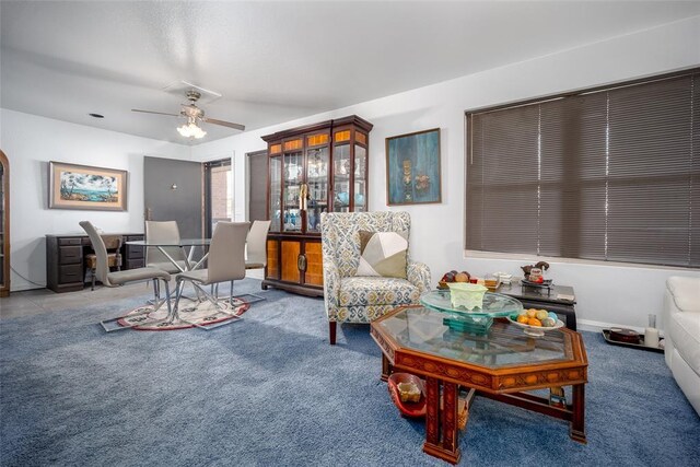 living room with a ceiling fan and carpet