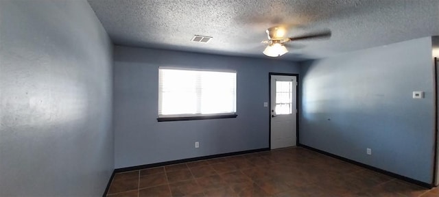 unfurnished room with a textured ceiling, baseboards, and ceiling fan