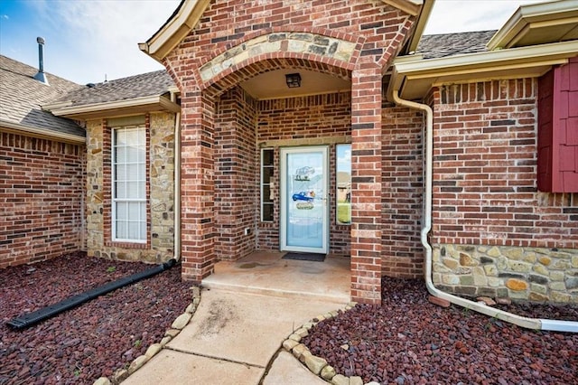 property entrance with brick siding and roof with shingles