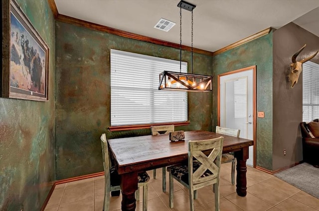 dining room with an inviting chandelier, light tile patterned floors, crown molding, and visible vents
