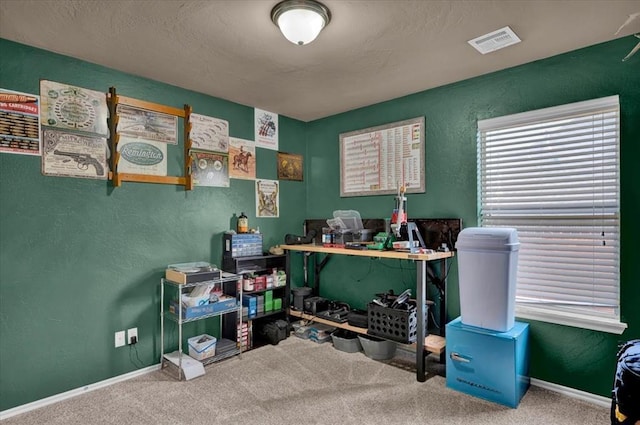 interior space featuring visible vents, a textured wall, carpet floors, and baseboards