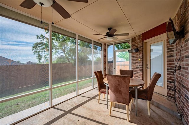 sunroom / solarium with ceiling fan and outdoor dining area