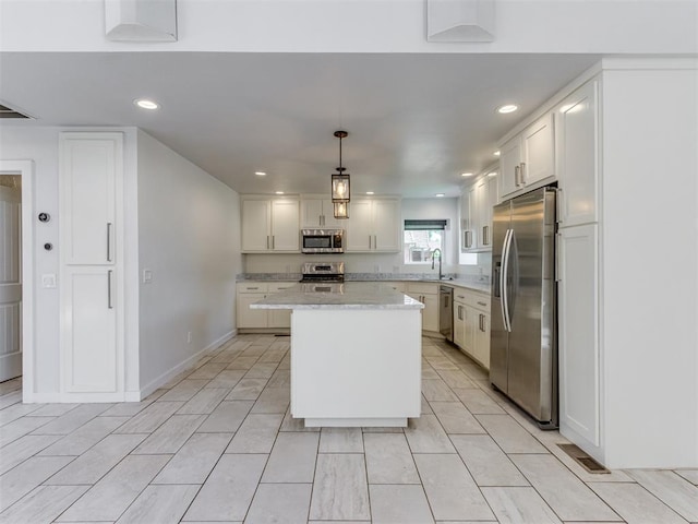 3233 Hickory Stick Rd, Oklahoma City, OK 73120 - kitchen featuring appliances with stainless steel finishes, a center island, recessed lighting, decorative light fixtures, and white cabinets