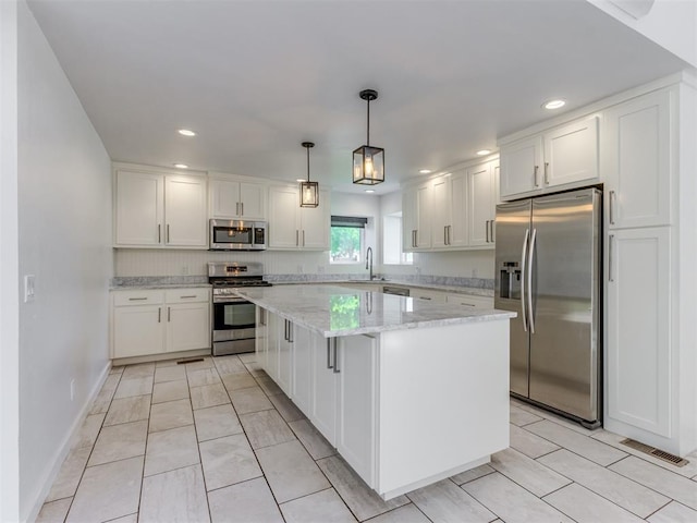 3233 Hickory Stick Rd, Oklahoma City, OK 73120 - kitchen with appliances with stainless steel finishes, white cabinetry, a kitchen island, light stone counters, and recessed lighting