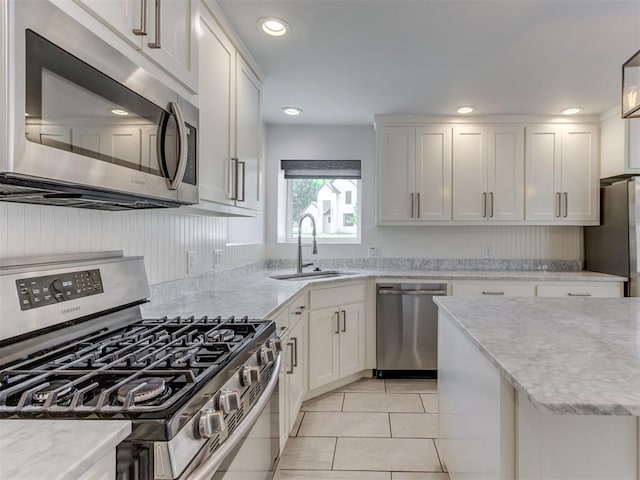 3233 Hickory Stick Rd, Oklahoma City, OK 73120 - kitchen with appliances with stainless steel finishes, white cabinets, light tile patterned floors, light stone counters, and recessed lighting