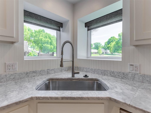 3233 Hickory Stick Rd, Oklahoma City, OK 73120 - kitchen view of light stone countertops, white cabinetry, and dishwasher