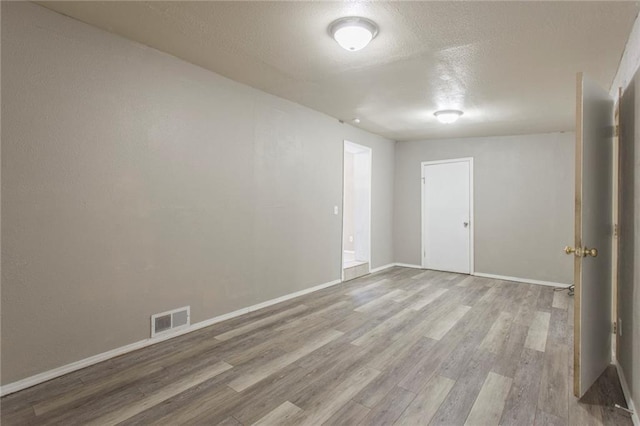 556 SW 52nd St, Oklahoma City, OK 73109 - spare room with baseboards, a textured ceiling, visible vents, and wood finished floors