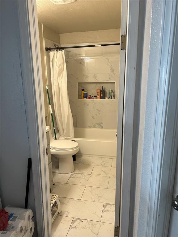 556 SW 52nd St, Oklahoma City, OK 73109 - full bathroom with toilet, shower / bath combo, and marble finish floor