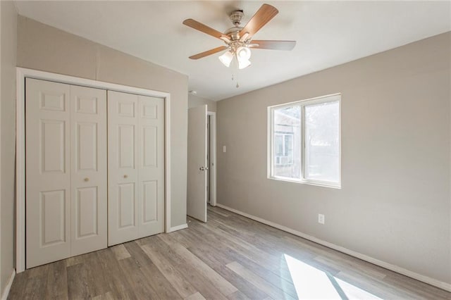 556 SW 52nd St, Oklahoma City, OK 73109 - unfurnished bedroom featuring baseboards, a ceiling fan, wood finished floors, and a closet