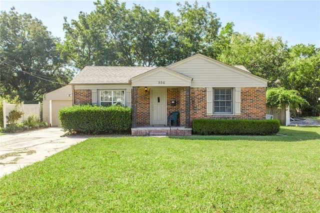 556 SW 52nd St, Oklahoma City, OK 73109 - view of front of home featuring brick siding, an attached garage, driveway, and a front yard