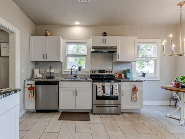 2247 NW 35th St, Oklahoma City, OK 73112 - kitchen with a sink, backsplash, under cabinet range hood, and stainless steel appliances