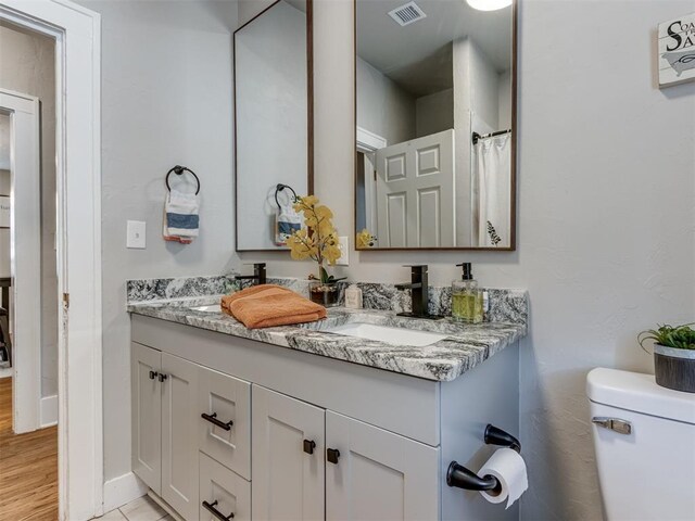 2247 NW 35th St, Oklahoma City, OK 73112 - bathroom featuring visible vents, a sink, double vanity, and toilet