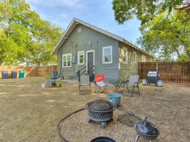 2247 NW 35th St, Oklahoma City, OK 73112 - rear view of property with a fenced backyard, an outdoor fire pit, and central AC