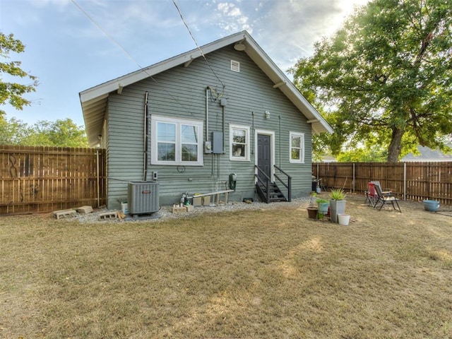 2247 NW 35th St, Oklahoma City, OK 73112 - back of house with entry steps, a lawn, a fenced backyard, and central AC