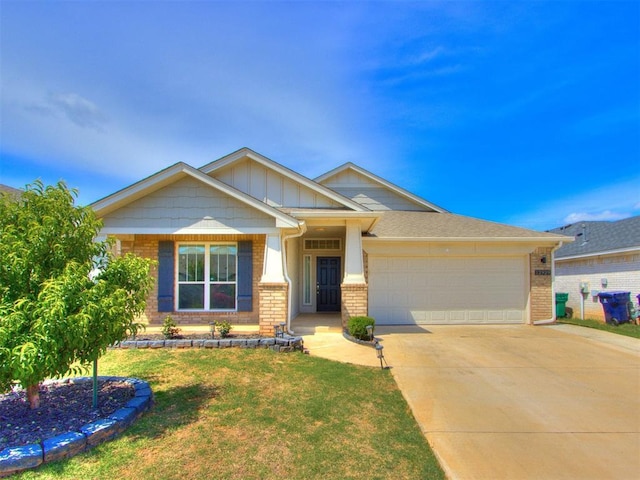 craftsman inspired home with concrete driveway, brick siding, a front yard, and a garage