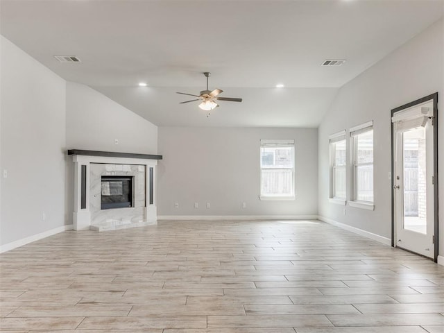 unfurnished living room featuring visible vents, a ceiling fan, light wood-style floors, and vaulted ceiling