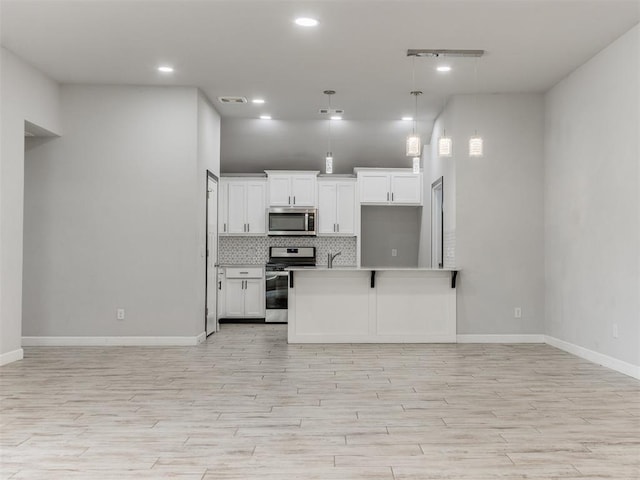 kitchen with backsplash, stainless steel appliances, open floor plan, and white cabinets