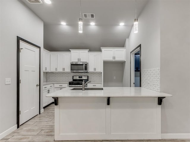 kitchen featuring backsplash, stainless steel appliances, visible vents, and a sink