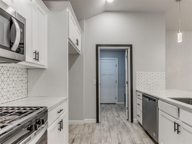 kitchen with light countertops, white cabinetry, appliances with stainless steel finishes, and decorative backsplash