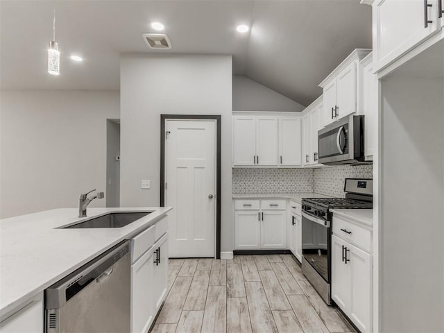 kitchen featuring decorative backsplash, light countertops, white cabinetry, a sink, and appliances with stainless steel finishes