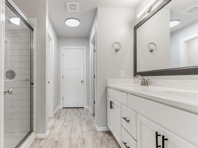 full bathroom featuring vanity, baseboards, visible vents, and a stall shower
