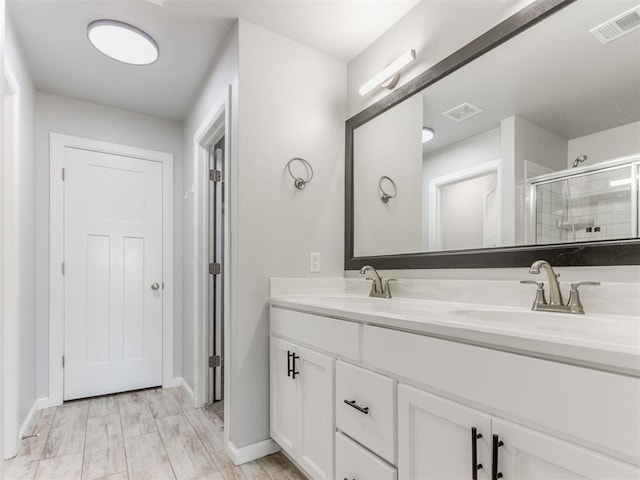 bathroom with visible vents, a sink, baseboards, and a stall shower