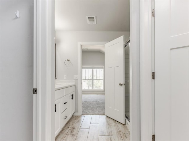 full bath with a stall shower, visible vents, wood finished floors, and vanity