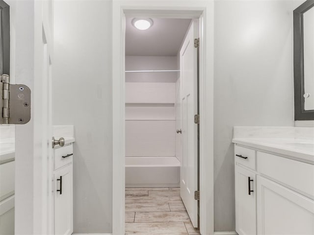 bathroom featuring shower / bath combination, vanity, and wood finished floors