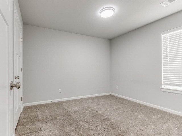 empty room featuring carpet floors, baseboards, and visible vents