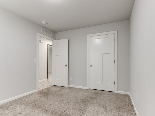 unfurnished bedroom featuring baseboards, carpet flooring, and visible vents