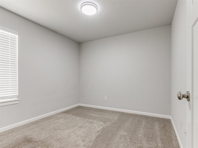 carpeted spare room with baseboards