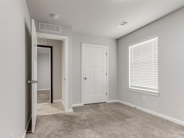 unfurnished bedroom with visible vents, baseboards, and carpet floors