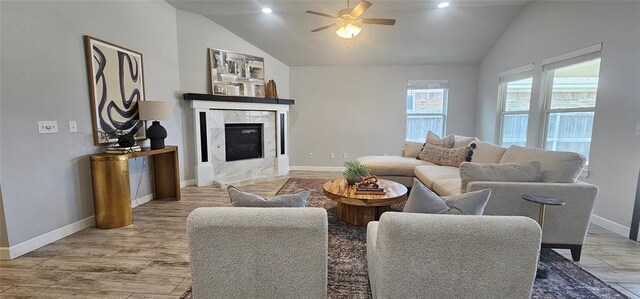 12929 NW 4th St, Yukon, OK 73099 - living area with vaulted ceiling, ceiling fan, a high end fireplace, light wood-type flooring, and baseboards