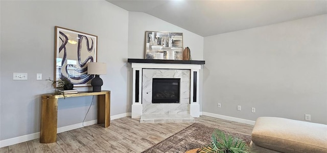 12929 NW 4th St, Yukon, OK 73099 - living area with wood finished floors, baseboards, vaulted ceiling, and a premium fireplace