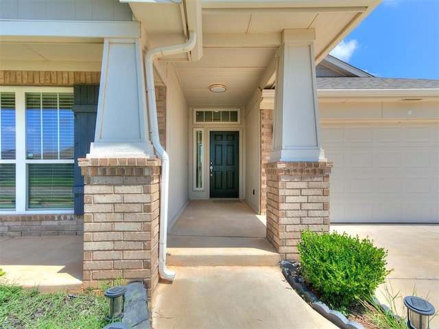 12929 NW 4th St, Yukon, OK 73099 - view of exterior entry with a garage, driveway, and brick siding