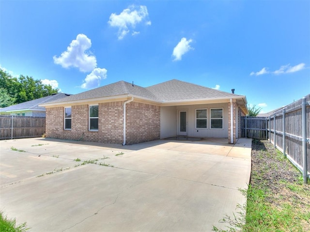 12929 NW 4th St, Yukon, OK 73099 - rear view of house with a patio area, brick siding, a fenced backyard, and concrete driveway