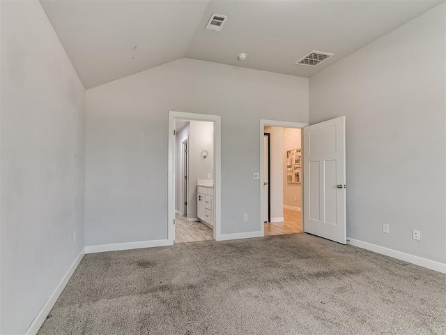 12929 NW 4th St, Yukon, OK 73099 - unfurnished bedroom featuring light colored carpet, lofted ceiling, and ensuite bath