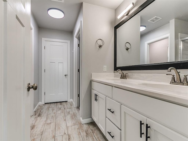 12929 NW 4th St, Yukon, OK 73099 - bathroom featuring double vanity and wood finished floors